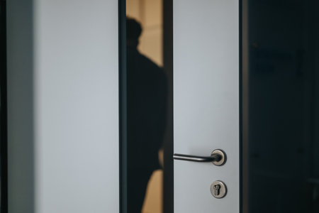 Silhouette of a person through a partially open office door