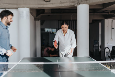 Business coworkers playing table tennis in modern office spaceの写真素材