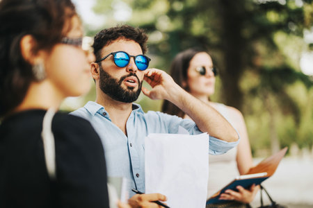 Business people having a meeting in a sunny park setting
