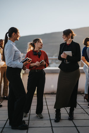 Diverse business colleagues brainstorming on rooftop at sunsetの写真素材