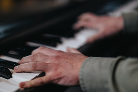 Hands playing piano keys during an intimate music performance