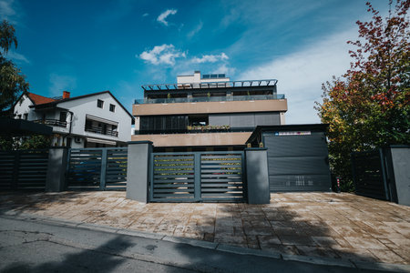 Modern residential building with gated entrance and bright outdoor atmosphereの写真素材
