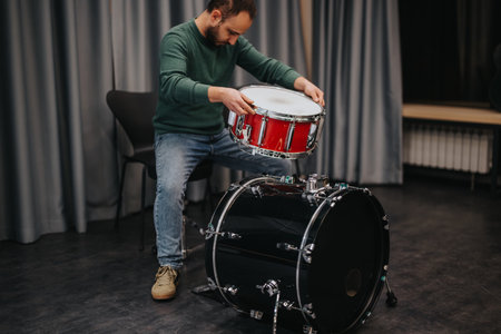 Man setting up drums in music studio for practice session