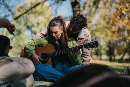 Young couple enjoying a guitar session in sunny autumn park