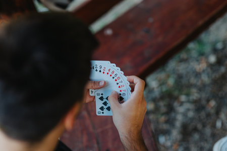 Close-up of a person holding a deck of playing cards outdoors