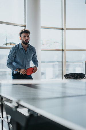 Business worker enjoying a break playing table tennis in officeの写真素材