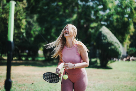 Joyful woman playing outdoor casual game in sunny park