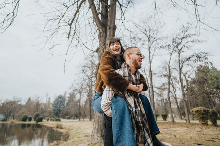 Friends enjoying a playful moment outdoors in the autumn seasonの写真素材