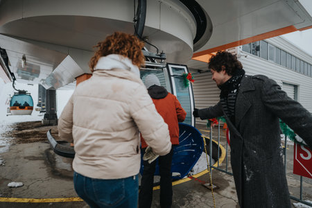 Friends boarding a gondola lift during a snowy winter adventureの写真素材