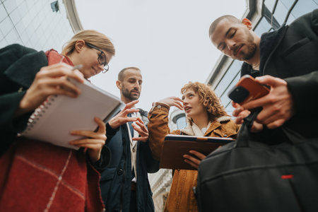 Group of professionals having a discussion with notebooks and tablets outdoors