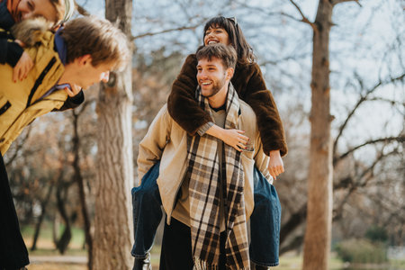 Group of friends sharing joy and laughter during a fun autumn outingの写真素材