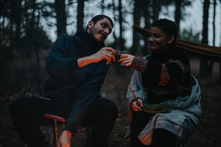 Friends Enjoying a Cozy Winter Evening Picnic by a Campfire in the Forestの写真素材
