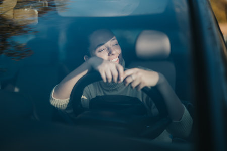Joyful woman enjoying a sunny day while driving her carの写真素材