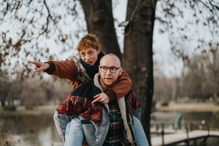 Young couple enjoying a playful moment together outdoors in a natural parkの写真素材