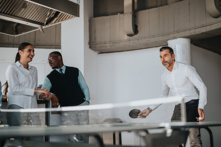 Multicultural business workers enjoying a break playing table tennis