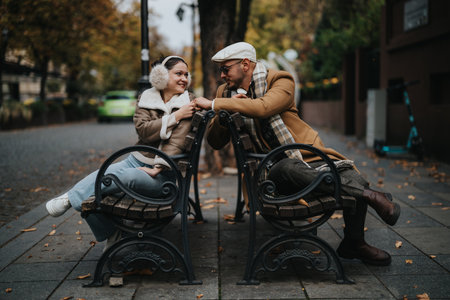 Happy couple enjoying autumn day on a city street benchの写真素材