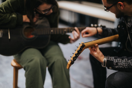 Music lesson with two guitarists during a collaborative practice sessionの写真素材