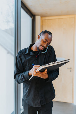 Professional multitasking person with notebook while speaking on the phone