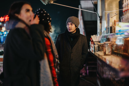 Group of friends enjoying street food during a winter evening outing