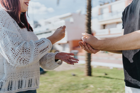 Two friends engage in a rock-paper-scissors game outdoors on a sunny dayの写真素材