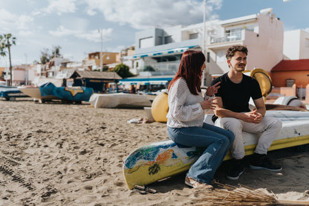 Casual conversation between friends on a sandy beach with colorful surroundingsの写真素材