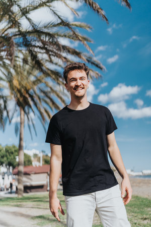 Portrait of a smiling man enjoying a sunny day outdoors near palm trees and a parkの写真素材