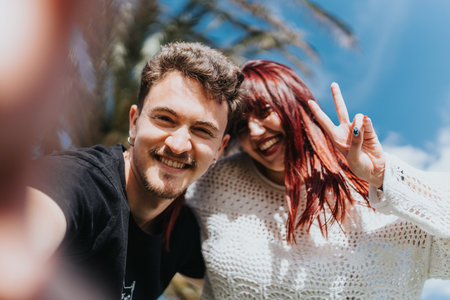 Smiling diverse friends taking a selfie under a bright blue sky outdoors