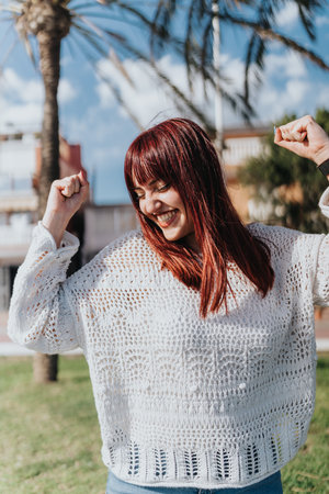 Smiling woman enjoying a sunny day outdoors with palm trees in the backgroundの写真素材