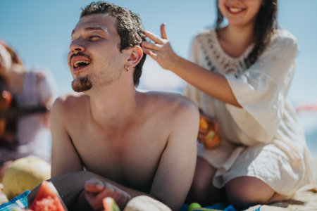 Group of friends enjoying laughter and relaxation on a sunny beach outing