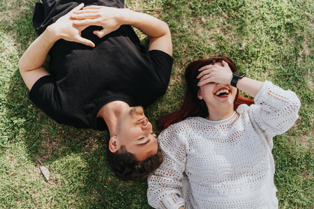 Young couple laughing together while relaxing on a sunny day outdoors in Spain