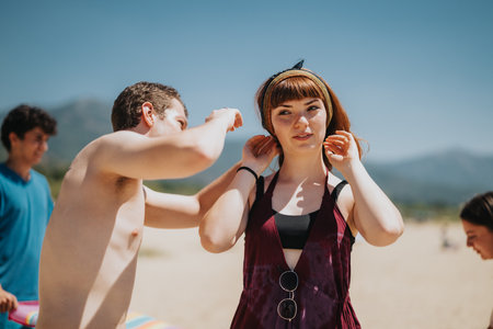 Friends enjoying a sunny day outdoors at the beach under clear blue skyの写真素材
