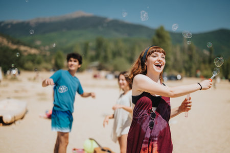 Group of friends enjoying bubbles on a sunny day at a beach