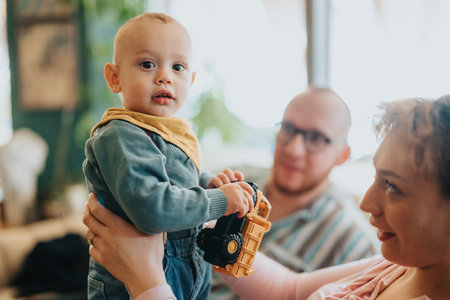 A family moment with parents and a child playing with a toy truck in a cozy home interior settingの写真素材