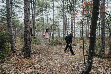 Group of friends hiking through a forest on a cloudy dayの写真素材