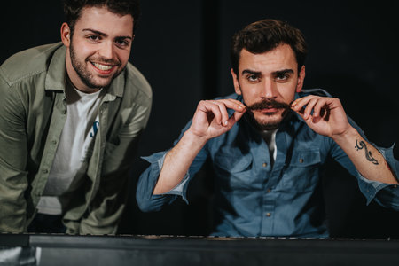 Two friends enjoying a moment, with one displaying his styled mustacheの写真素材