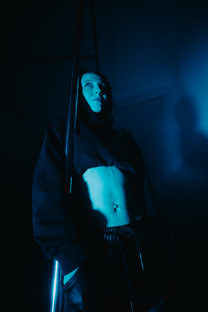 Pole dancer in artistic blue lighting with focus on athleticismの写真素材