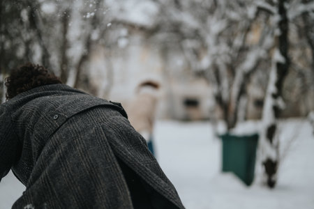 Friends enjoying playful moments outdoors on a snowy winter dayの写真素材