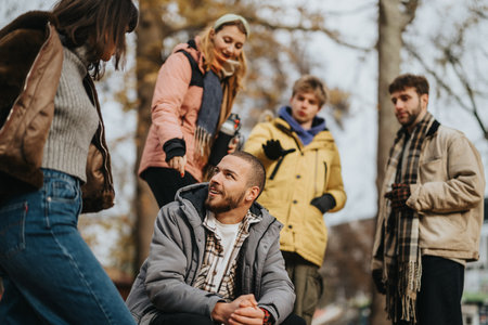 Group of friends connecting outdoors in cold weather for leisure and conversationの写真素材