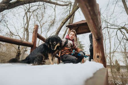 Group enjoying outdoors in winter with a dog on a snowy dayの写真素材