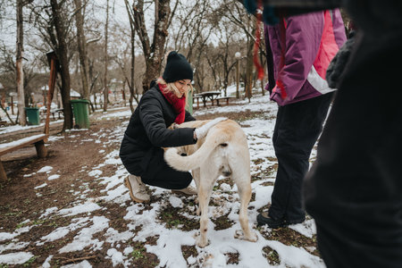 Playful moments with a dog outdoors during a snowy winter dayの写真素材