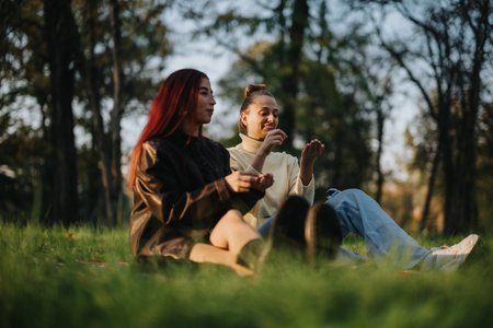 Two friends enjoying a peaceful afternoon together in a green parkの写真素材
