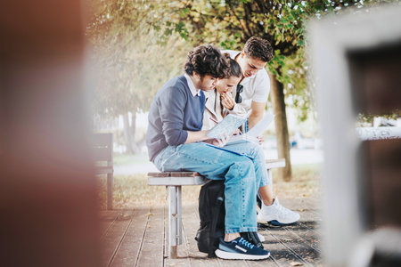 Group of students studying together in a park on a sunny dayの写真素材