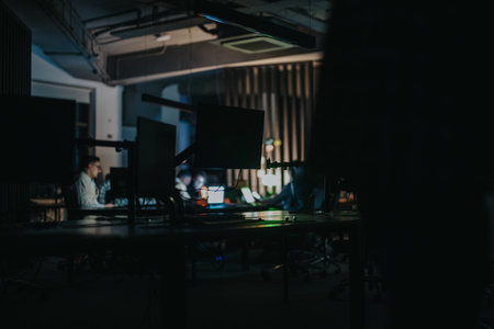 Multiracial colleagues collaborating in an office during evening hours, engaged in discussions and strategizing for upcoming projects and deadlines.の写真素材
