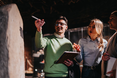 Group visiting a museum and discussing exhibits in a collaborative and engaging settingの写真素材