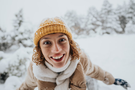 Cheerful person enjoying winter snow with a bright smile and warm attire