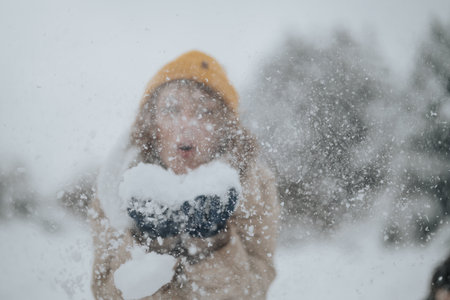 Person enjoying the snow with a playful gesture during winter