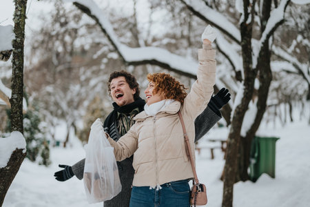 Joyful friends enjoying a winter day outdoors in a snowy park