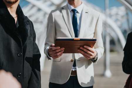Business Professional Holding a Clipboard Outdoors During a Meetingの写真素材