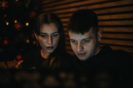 Two people focus on a task together in a cozy indoor setting.の写真素材