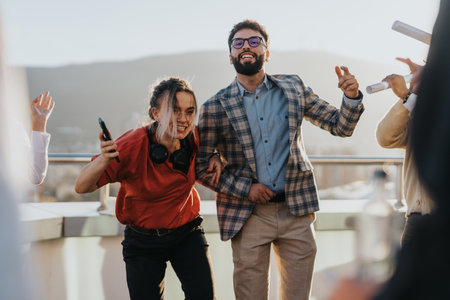 Business colleagues celebrating success on a sunset tower balcony partyの写真素材